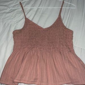 Light pink blouse, stretchy around the breast area, and flares at the bottom.